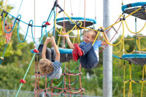 kids climbing on different ropes of adventure playground